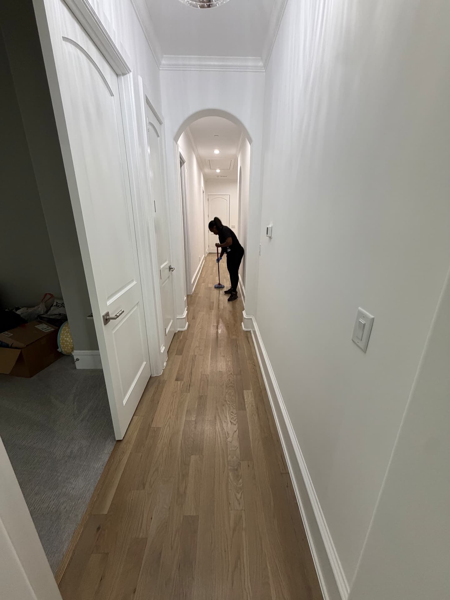 Forever Family cleaner mopping a long hallway in a large DFW home