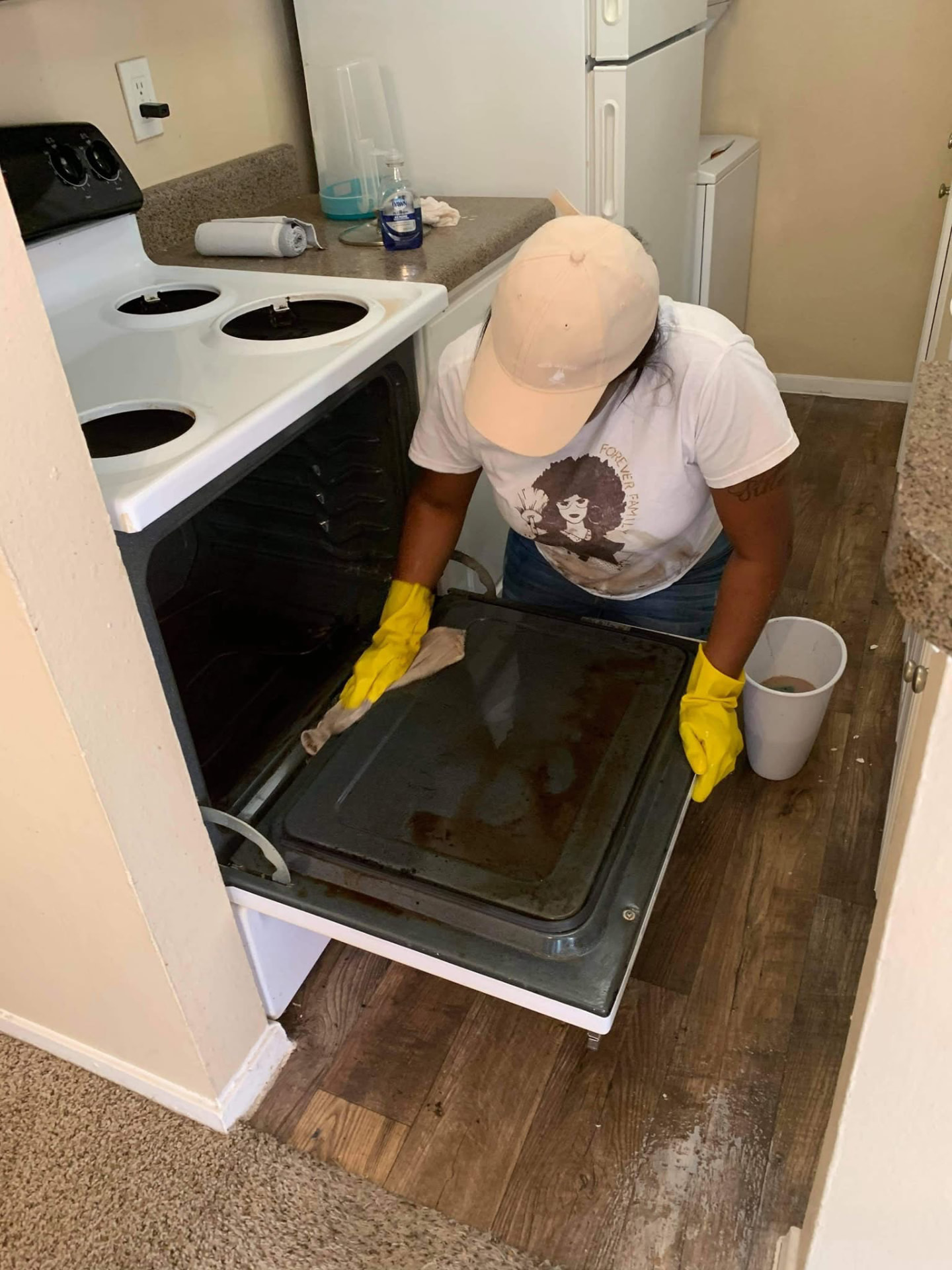 Forever Family cleaner scrubbing an oven door